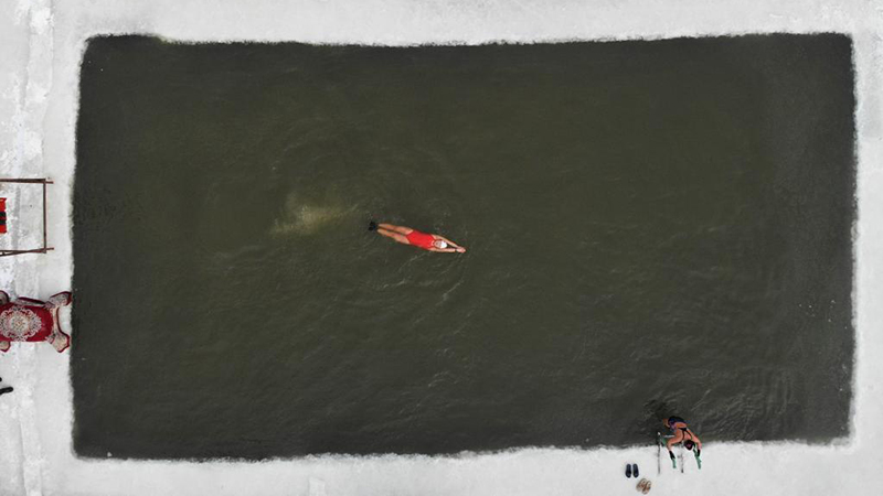 Winterschwimmer schwimmt im Fluss Songhua in Harbin
