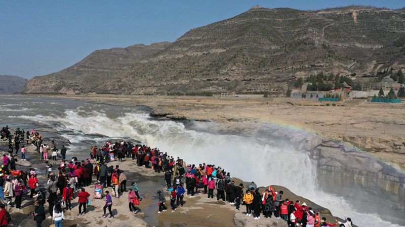 Touristen genießen Landschaft des Hukou-Wasserfalls in Shaanxi